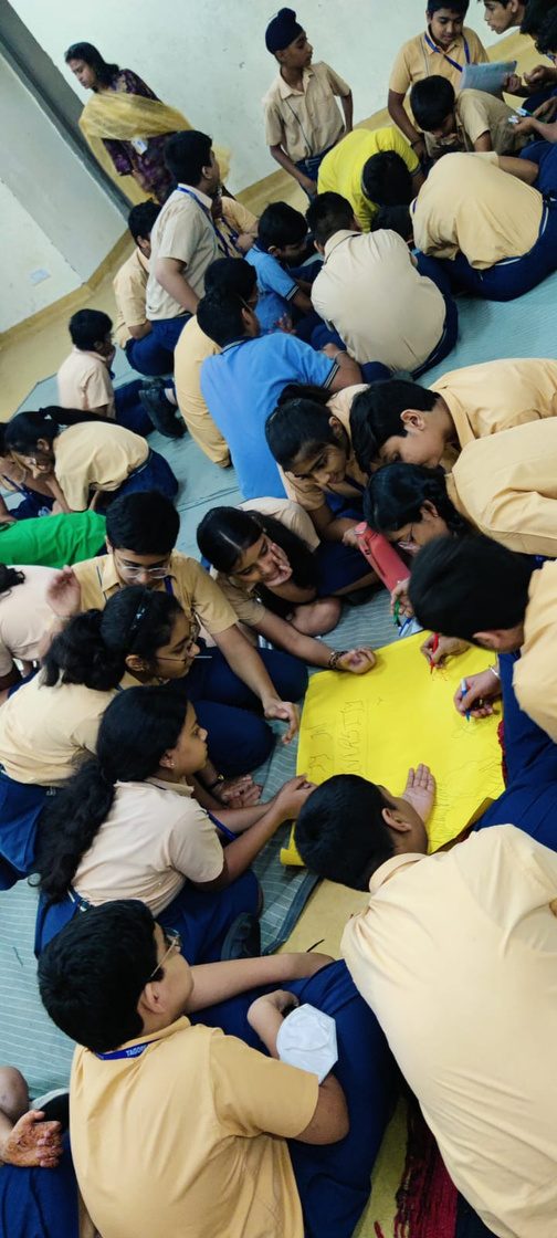 Students and facilitators sitting in a circle on the floor during a workshop, deep in discussion.