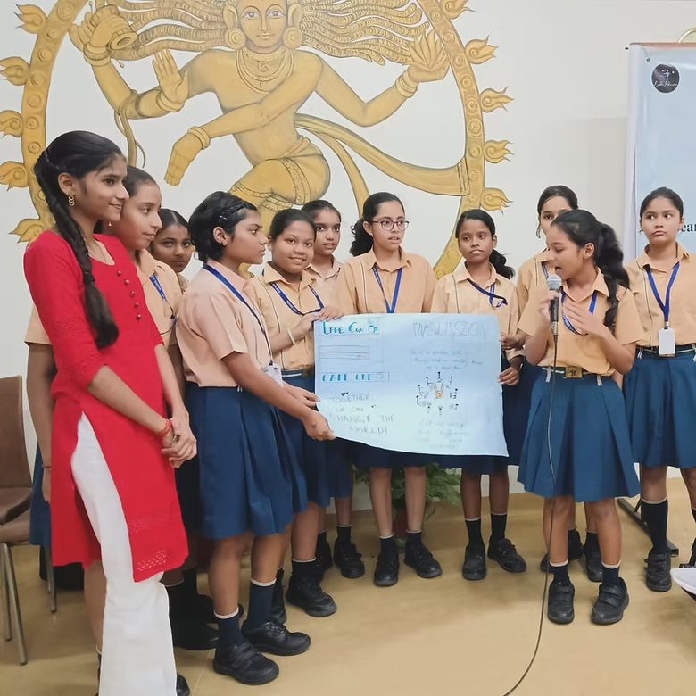 A facilitator standing in front of a classroom of school students during an awareness session.